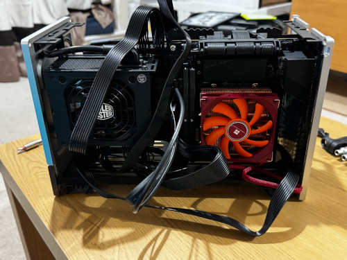 The computer fully built, but with the sides and top of the case off, and wires protruding everywhere.