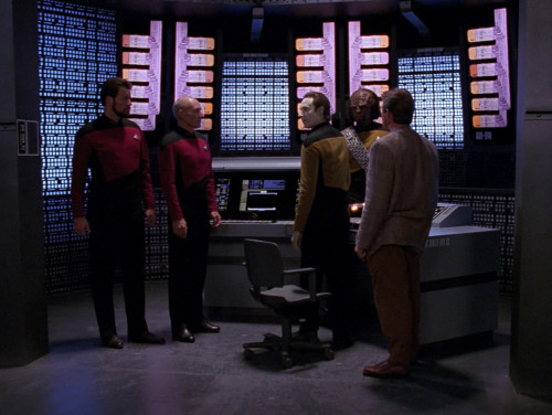 Still from an episode of Star Trek: The Next Generation, with various characters stood around in a computer core room